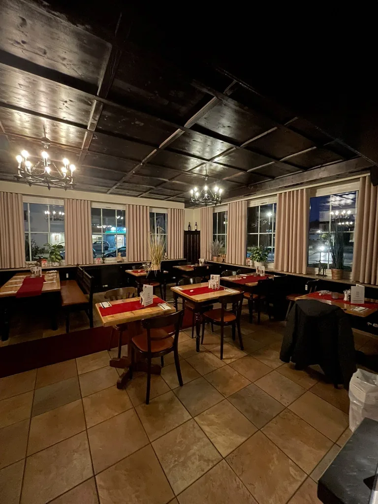 Kurze beige Gardinen an den Fenstern eines rustikalen Restaurants mit Holzdecke